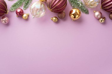 Yeni yıl dekorasyonu konsepti. Pembe, şeffaf ve altın renkli toplar ile izole edilmiş pastel eflatun arkaplanlı, boş arkaplanlı çam dallarının üst görüntüsü.