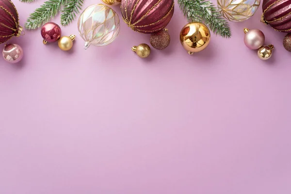 新年装饰的概念 冷冻土粉色透明的松树枝条和孤立的紫丁香背景上的金黄色小球的顶部照片 — 图库照片