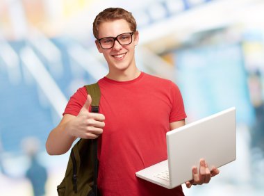 adam tutarak laptop ve sırt çantası