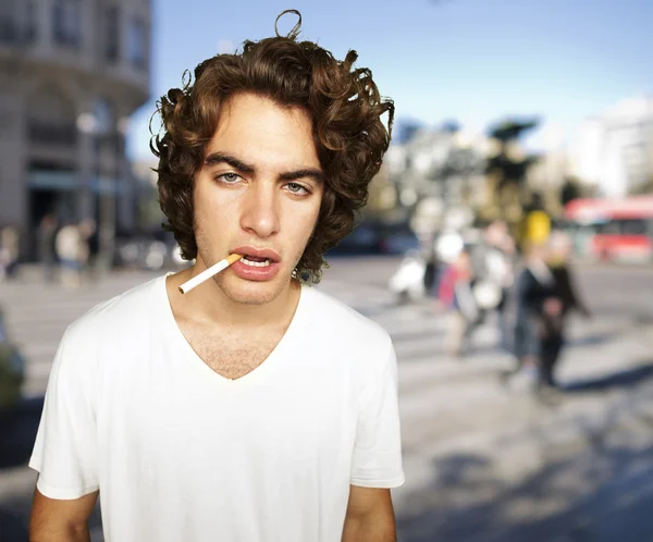 Portrait of a sad smoker at crowded city — Stock Photo, Image