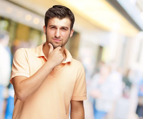 Portret van jonge man aan te raken is kin — Stockfoto