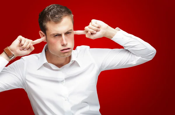 Portret van een jonge man met vinger in zijn oor — Stockfoto