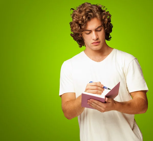 A Young Man Writing On A Notebook — Stock Photo, Image