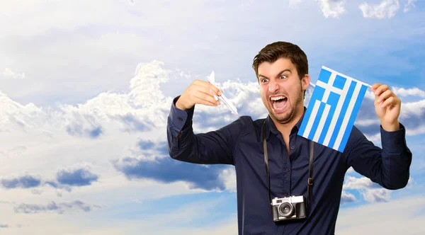 Homem segurando bandeira e avião em miniatura — Fotografia de Stock