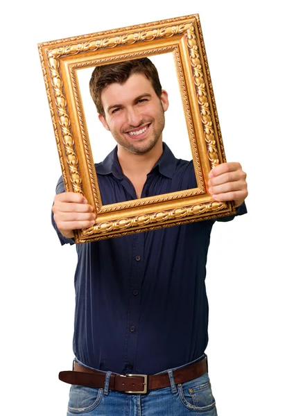 Um jovem segurando e olhando através do quadro — Fotografia de Stock