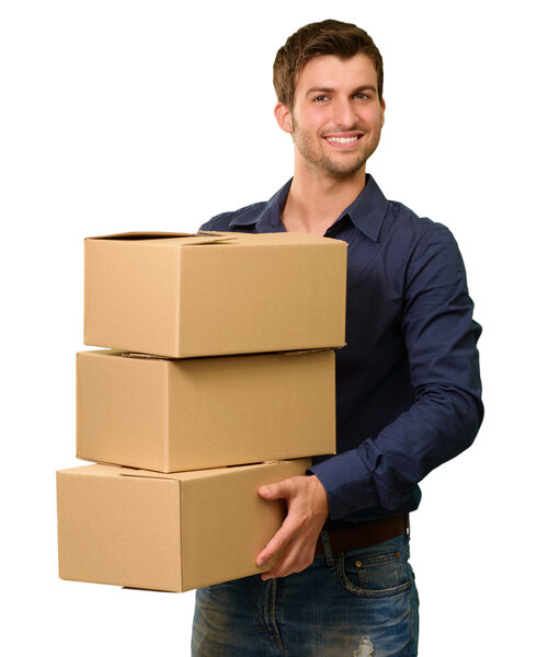 Молодой человек держит стопку картонных коробок
