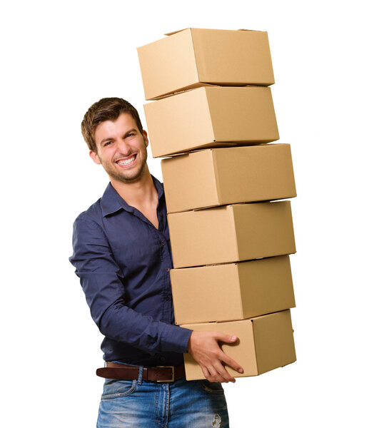 Молодой человек держит стопку картонных коробок
