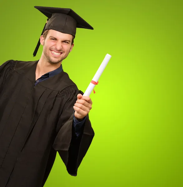 Giovane uomo in abito da laurea in possesso di certificato — Foto Stock