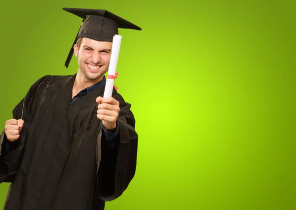 Jonge man in afstuderen jurk bedrijf certificaat — Stockfoto