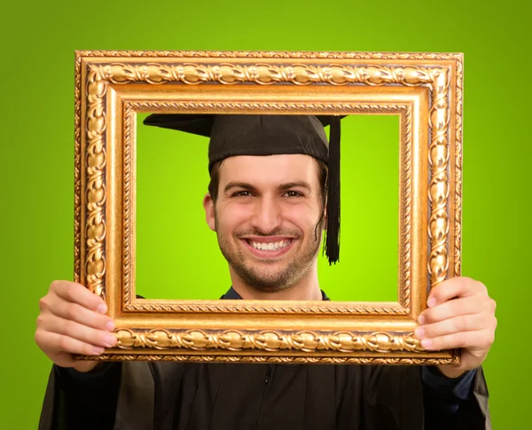 Afgestudeerde man die door een frame — Stockfoto