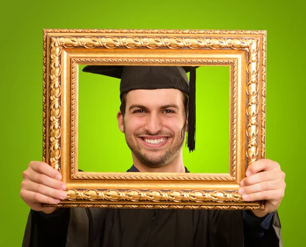 Hombre graduado mirando a través de un marco — Foto de Stock