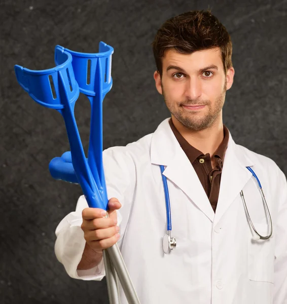 Portrait Of A Young Doctor Holding Crouches — Stock Photo, Image