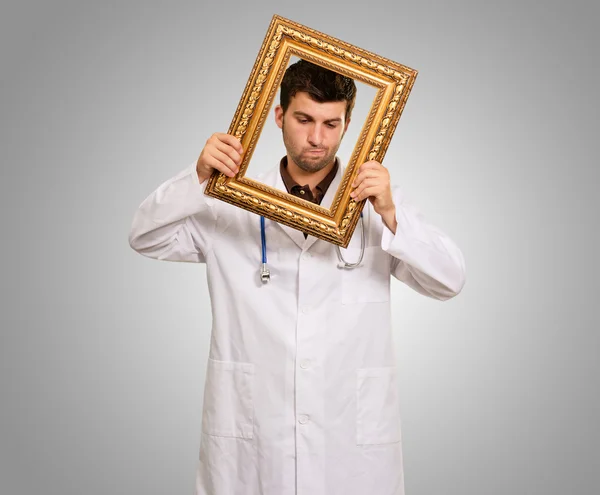 Retrato de un médico sosteniendo un marco — Foto de Stock