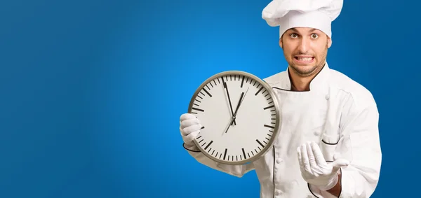 Шеф-повар держит настенные часы — стоковое фото
