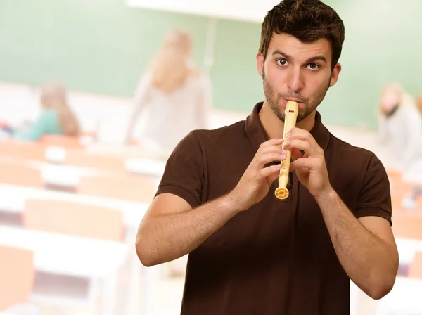 Porträtt av en ung man som spelar flöjt — Stockfoto