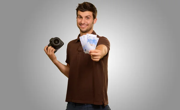 Hombre sosteniendo la cámara y el dinero — Foto de Stock