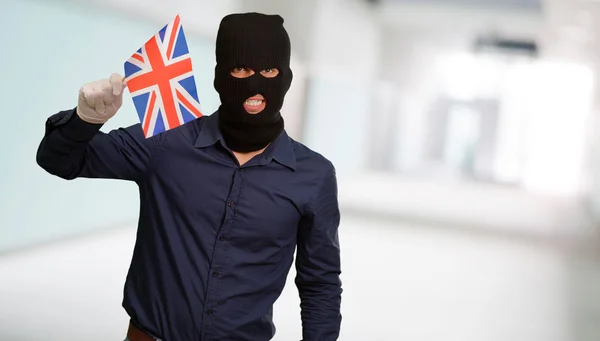 Portrait of a man wearing mask holding a flag — Stock Photo, Image