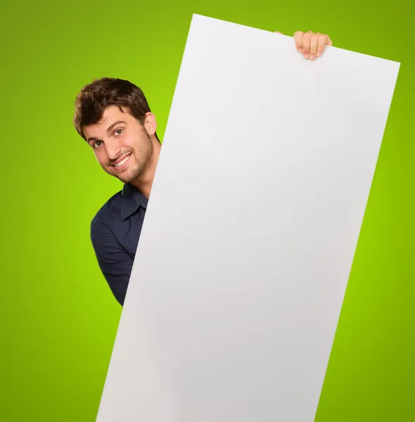 Joven sosteniendo papel en blanco — Foto de Stock