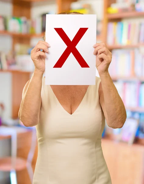 Reife Frau mit Buchstabe x Schild — Stockfoto