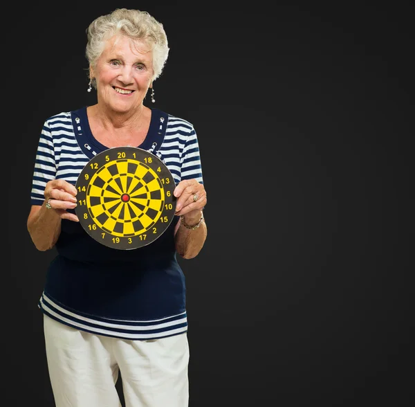 Seniorin steht mit Dartscheibe — Stockfoto