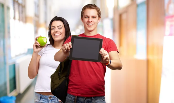 Estudantes segurando tablet e frutas — Fotografia de Stock