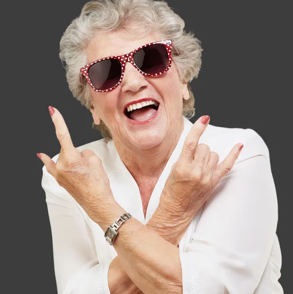 Senior vrouw dragen van een zonnebril doet funky actie — Stockfoto