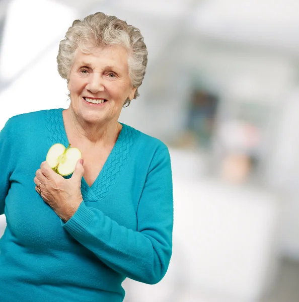 Porträt einer glücklichen reifen Frau beim Halten eines Apfels — Stockfoto