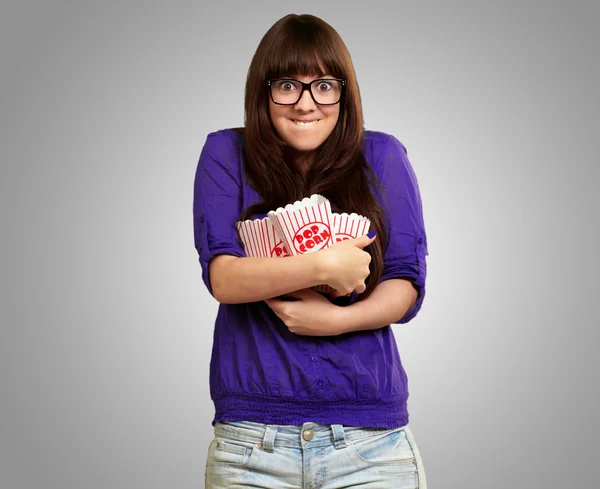 Retrato de mulher jovem segurando recipiente de pipoca — Fotografia de Stock