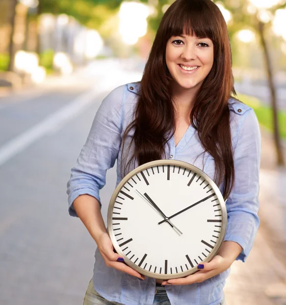 Une jeune fille tenant une horloge — Photo