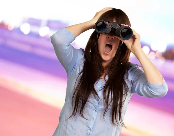 Ritratto di una giovane donna guardando attraverso binocoli — Foto Stock