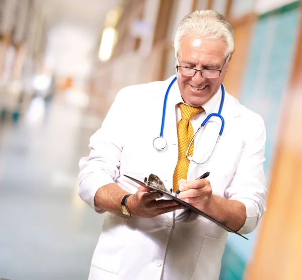 Heureux mâle docteur écriture sur presse-papiers — Photo