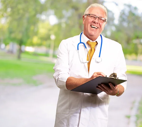 Gelukkig mannelijke arts schrijven op Klembord — Stockfoto