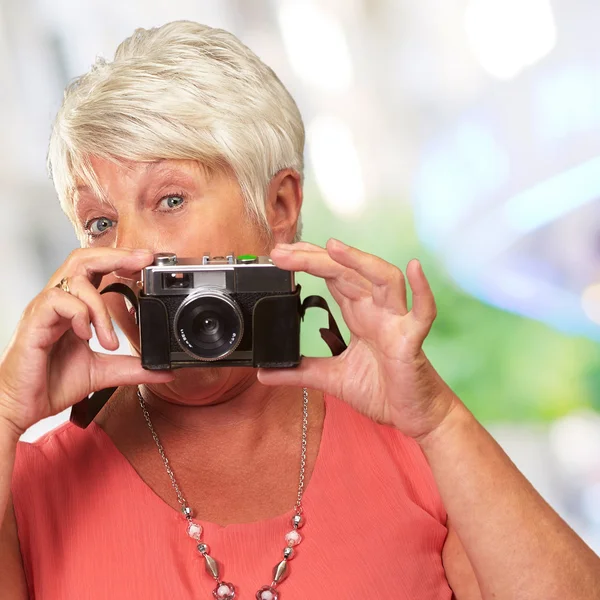 Äldre kvinna anläggning kamera — Stockfoto