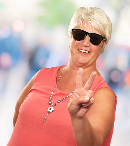 Portrait d'une femme âgée montrant un signe de victoire — Photo