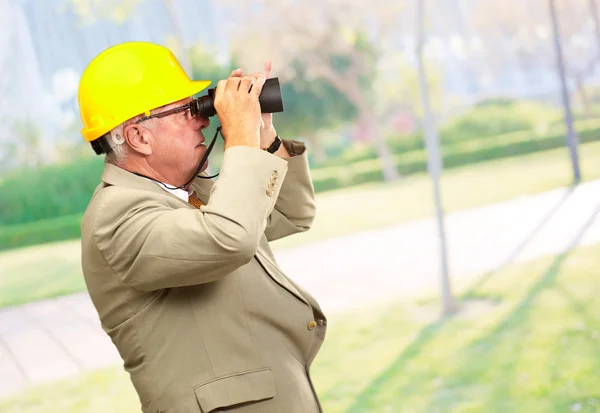 Arquitecto senior mirando a través de prismáticos — Foto de Stock