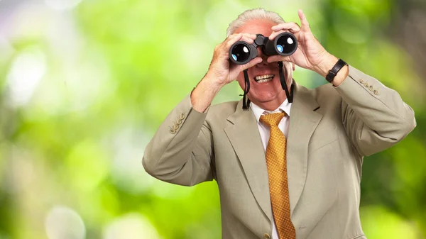 Senior schaut durch Fernglas — Stockfoto