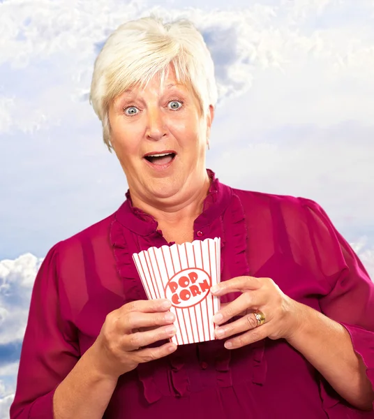 Vecchia donna mangiare popcorn — Foto Stock