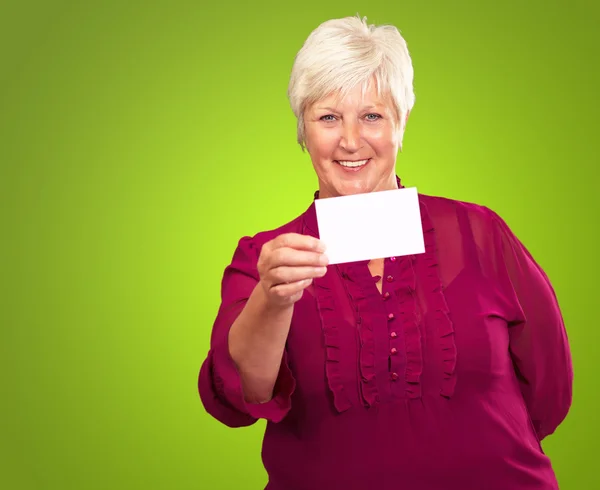 Retrato de una mujer mayor sosteniendo una tarjeta en blanco — Foto de Stock