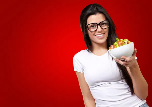 Chica joven mostrando un tazón de ensalada —  Fotos de Stock