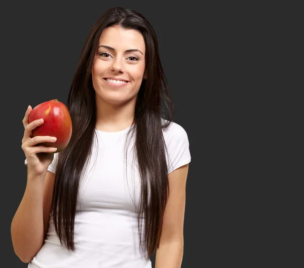 Una giovane donna con in mano un mango — Foto Stock