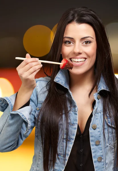 Porträt einer Frau, die Erdbeere mit Schokoladensauce isst — Stockfoto