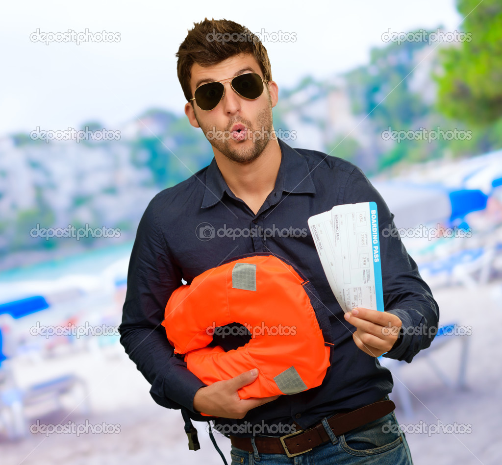 Man Standing With Boarding Passes And Bag