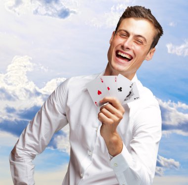 poker kartları gösterilen genç adam portresi