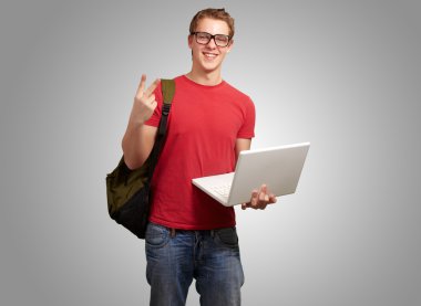 adam tutarak laptop ve sırt çantası