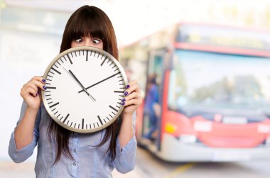 Woman Holding Clock With Squinted Eyes clipart