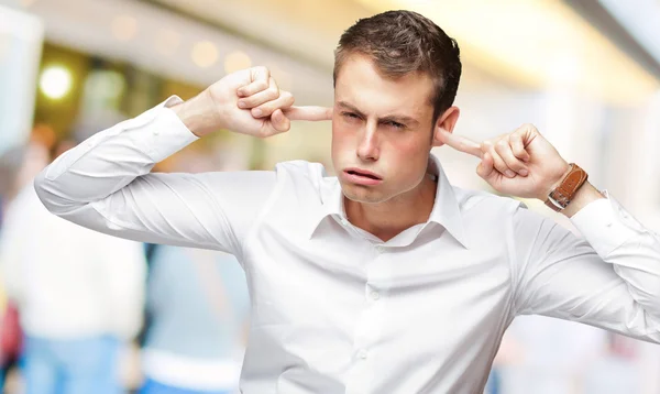 Portret van een jonge man met vinger in zijn oor — Stockfoto