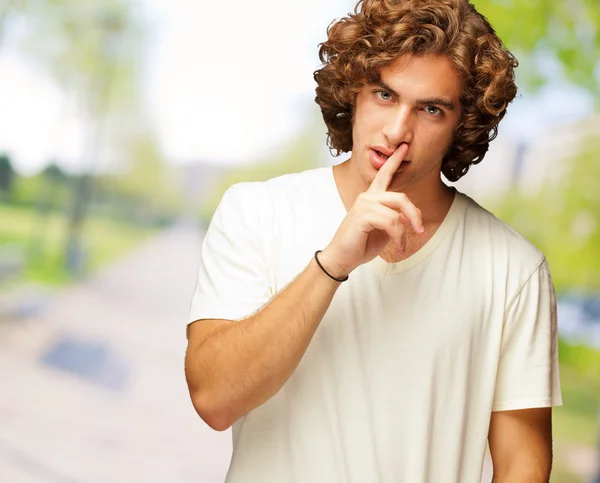 Retrato de un hombre con dedos en los labios — Foto de Stock