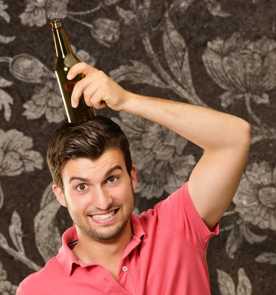 Retrato de un hombre sosteniendo la botella en la cabeza —  Fotos de Stock