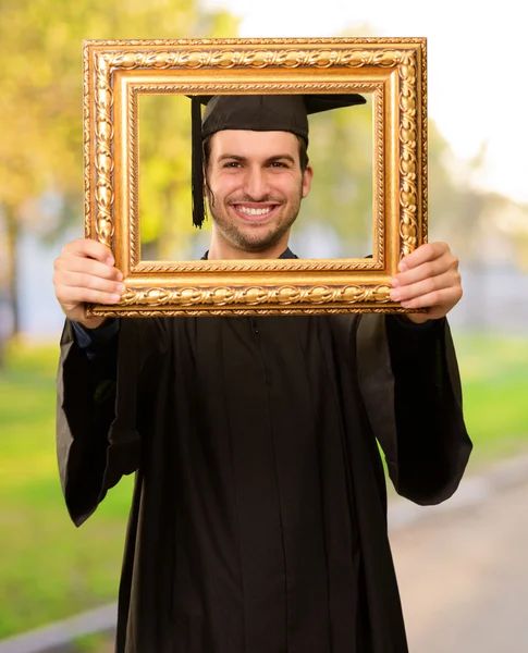 Absolvent schaut durch einen Rahmen — Stockfoto