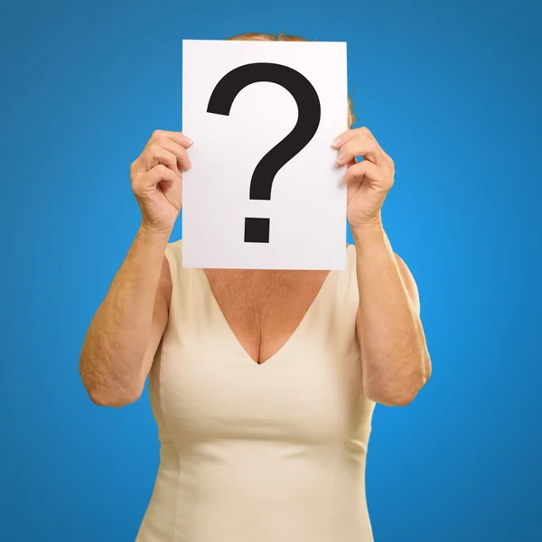 Mature woman holding question mark sign — Stock Photo, Image